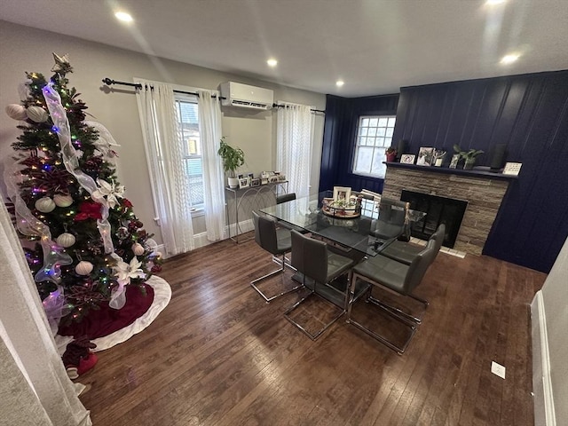 dining area with a wall mounted AC, a fireplace, and dark wood-type flooring