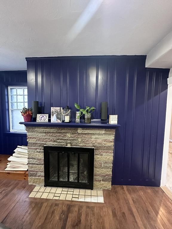 room details with wood-type flooring and a stone fireplace