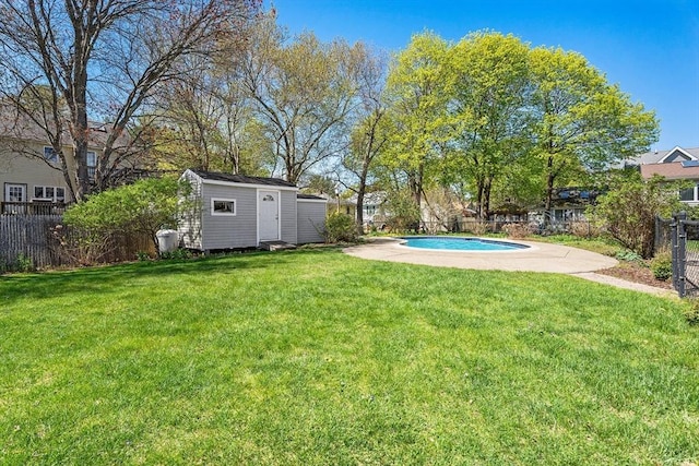 view of yard featuring a fenced in pool, a fenced backyard, an outbuilding, and a storage shed