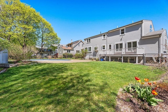 back of house featuring a lawn, fence, a residential view, and an outdoor pool