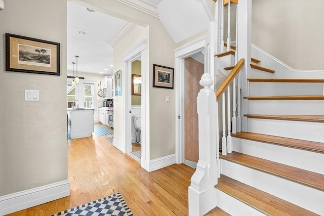 staircase featuring crown molding and hardwood / wood-style flooring