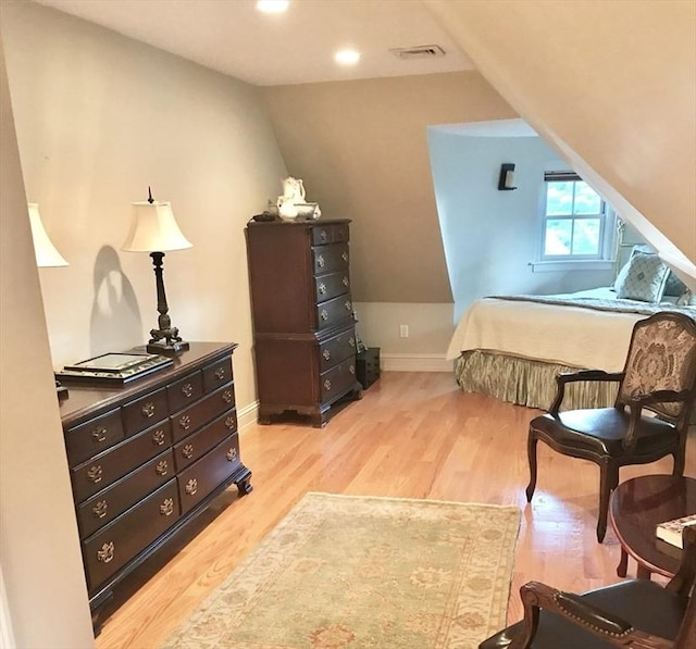 bedroom featuring light hardwood / wood-style floors and vaulted ceiling