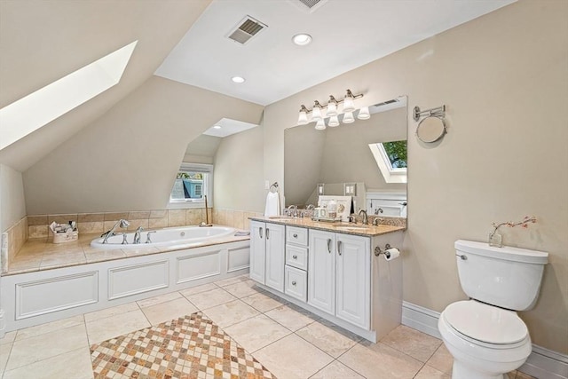 bathroom featuring vanity, toilet, lofted ceiling with skylight, and tile patterned flooring