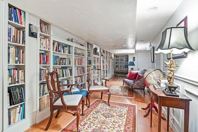 living area with built in shelves and light hardwood / wood-style floors