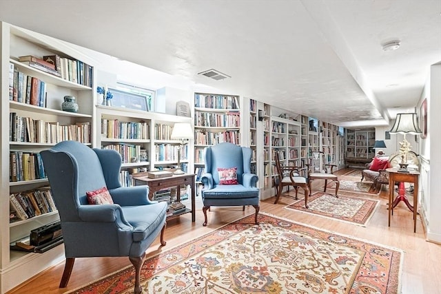 living area featuring hardwood / wood-style flooring and built in shelves