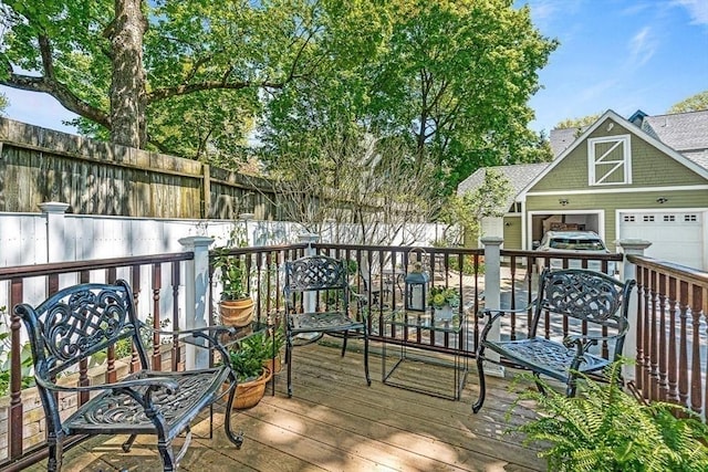 wooden deck featuring a garage and an outbuilding