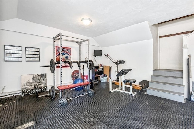 exercise area with vaulted ceiling and a textured ceiling