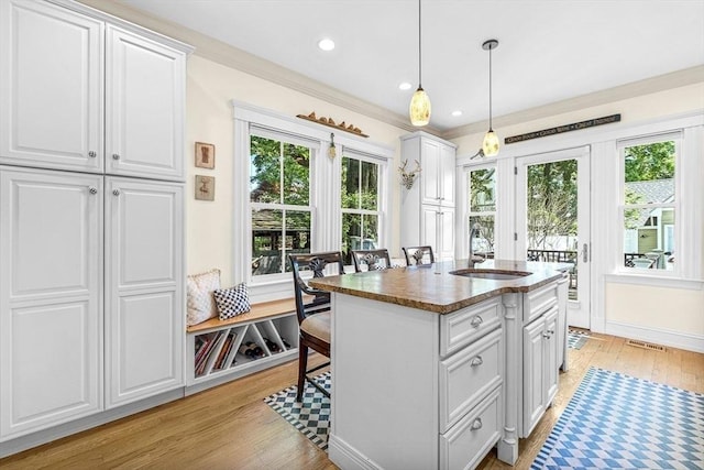 kitchen with sink, white cabinets, and pendant lighting