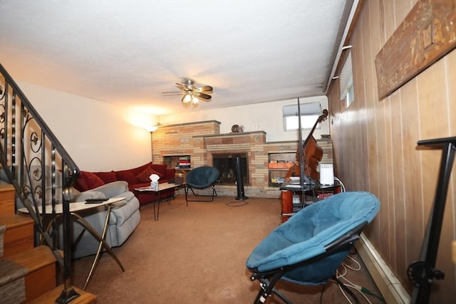 interior space with stairway, ceiling fan, carpet floors, and a stone fireplace