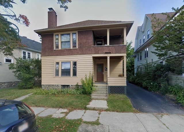 view of front of property with a balcony and a chimney