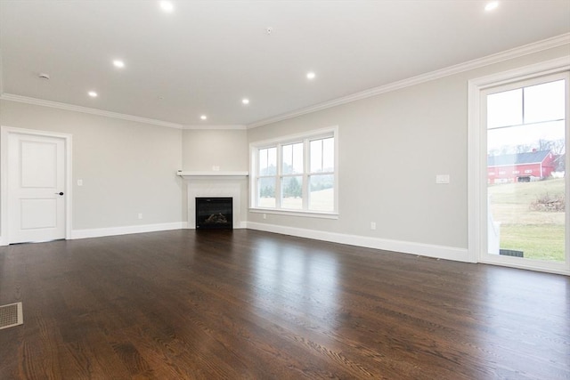 unfurnished living room featuring crown molding, plenty of natural light, and dark wood-type flooring