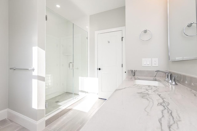 bathroom featuring sink and a shower with shower door