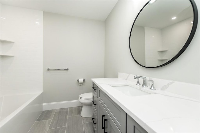 full bathroom featuring washtub / shower combination, vanity, and toilet