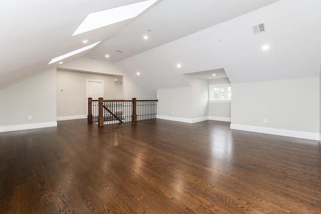 bonus room featuring dark hardwood / wood-style flooring and lofted ceiling with skylight