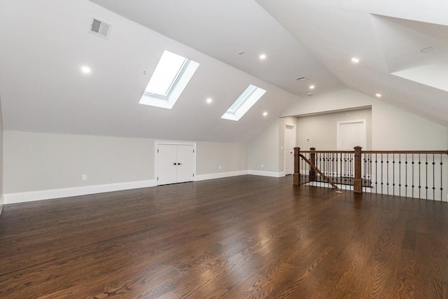 bonus room with dark hardwood / wood-style floors and lofted ceiling with skylight