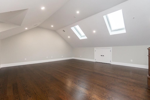 bonus room with dark hardwood / wood-style flooring and lofted ceiling with skylight