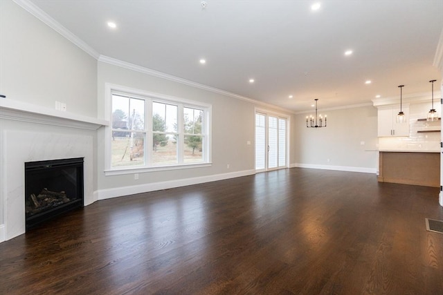 unfurnished living room featuring a notable chandelier, crown molding, and dark wood-type flooring