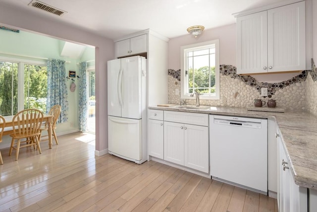 kitchen with sink, white cabinetry, light wood-type flooring, white appliances, and backsplash