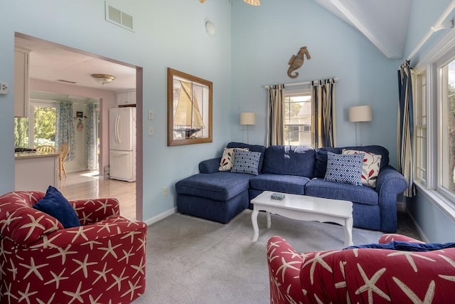 carpeted living room with high vaulted ceiling