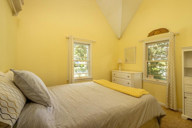 carpeted bedroom featuring multiple windows and vaulted ceiling