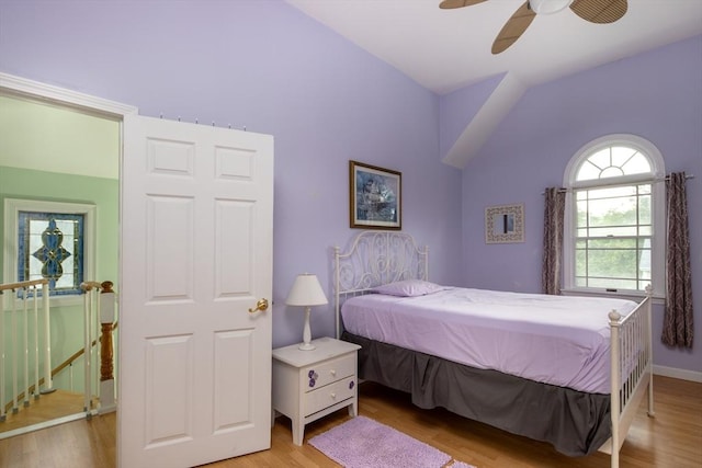 bedroom featuring wood-type flooring, vaulted ceiling, and ceiling fan