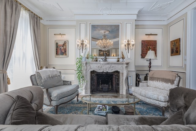 living room with a notable chandelier, a premium fireplace, and crown molding