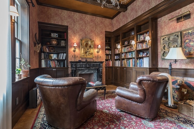 living area featuring a fireplace, dark parquet floors, built in shelves, and crown molding