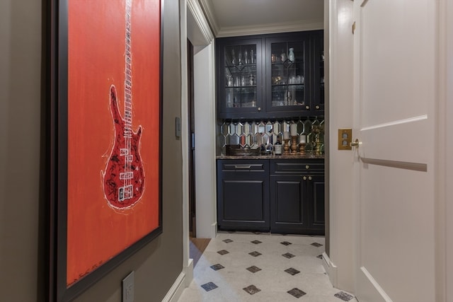 interior space featuring dark stone countertops, light tile flooring, and ornamental molding