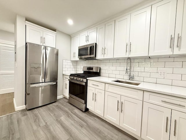 135 Granite Ave Unit 23, Boston, MA 02124 - kitchen featuring stainless steel appliances, a sink, white cabinetry, light wood finished floors, and backsplash