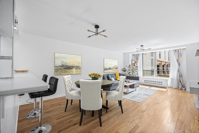 99 Pond Ave Unit 202, Brookline, MA 02445 - dining room with light wood-type flooring, a chandelier, and radiator heating unit