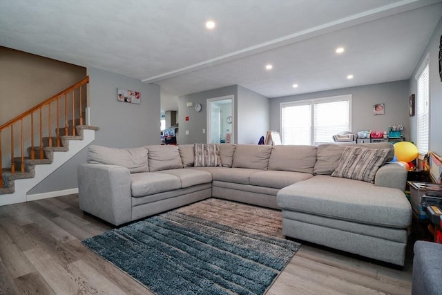 living room featuring baseboards, stairs, recessed lighting, and wood finished floors