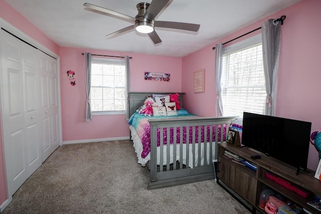 carpeted bedroom featuring a closet, baseboards, and a ceiling fan