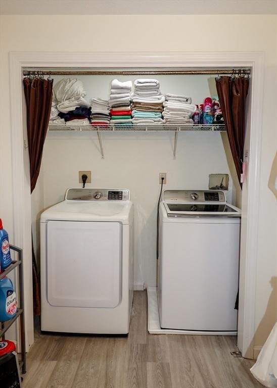 washroom with separate washer and dryer, laundry area, and light wood-type flooring