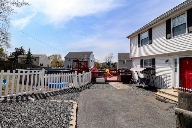 exterior space with fence, a patio, a deck, and a pool