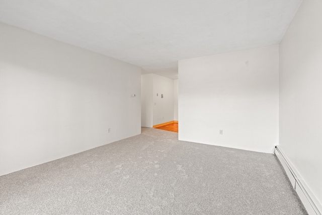 empty room with light colored carpet and a baseboard radiator