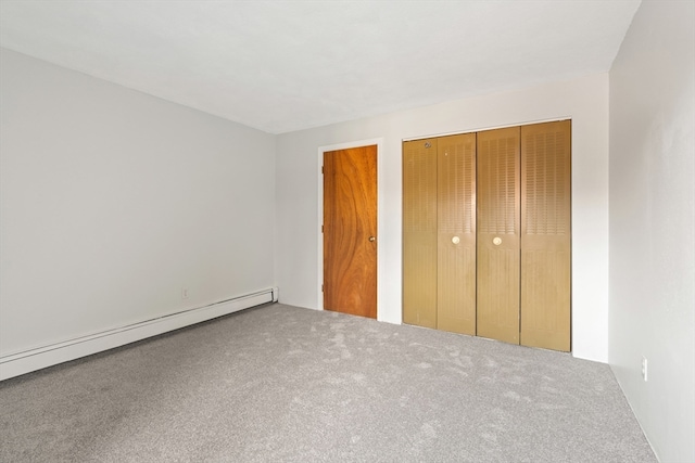 unfurnished bedroom featuring a closet, carpet, and a baseboard heating unit