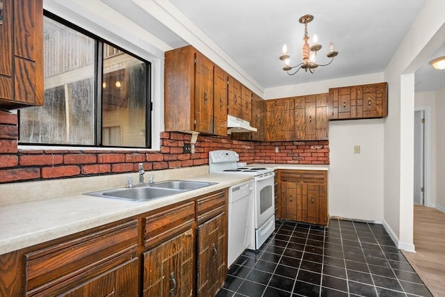 kitchen with backsplash, white appliances, sink, an inviting chandelier, and hanging light fixtures