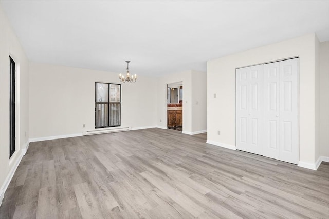 unfurnished living room with light wood-type flooring, a baseboard heating unit, and an inviting chandelier