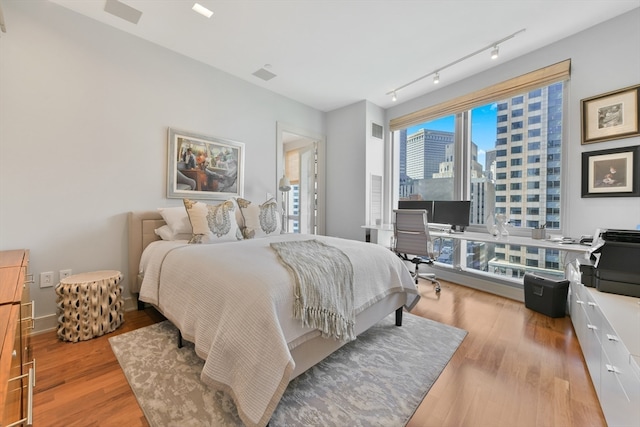 bedroom featuring track lighting and light hardwood / wood-style flooring