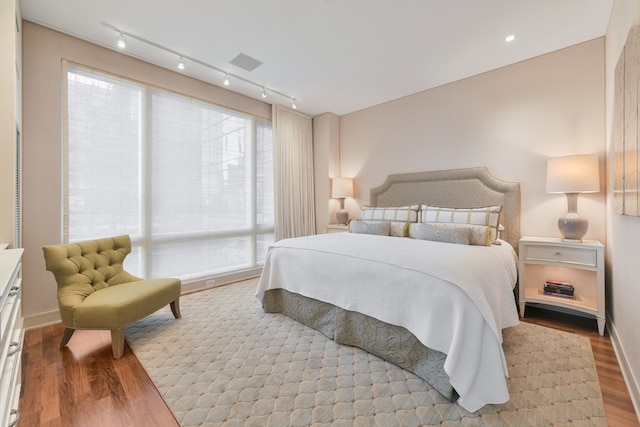 bedroom featuring light hardwood / wood-style floors and track lighting