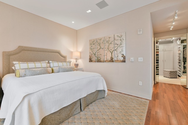 bedroom with hardwood / wood-style floors and rail lighting