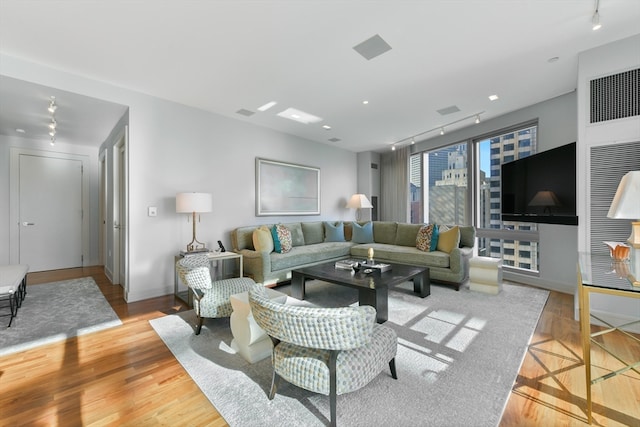 living room with track lighting and light hardwood / wood-style floors