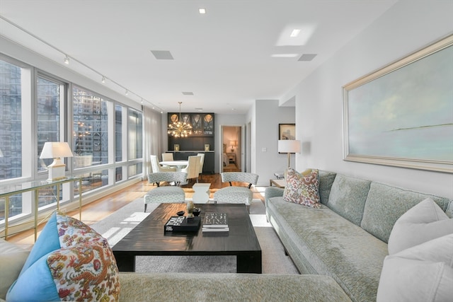 living room with a chandelier, hardwood / wood-style floors, and rail lighting