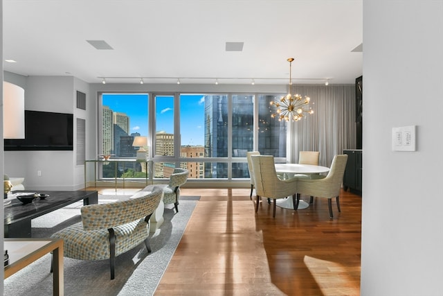 dining room with hardwood / wood-style flooring, an inviting chandelier, and track lighting