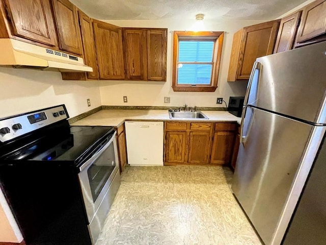 21 Hillside Ave Unit 21, Everett, MA 02149 - kitchen with appliances with stainless steel finishes, under cabinet range hood, brown cabinetry, and light countertops