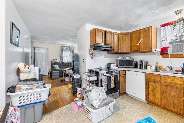 21 Hillside Ave Unit 21, Everett, MA 02149 - kitchen featuring appliances with stainless steel finishes, under cabinet range hood, light countertops, brown cabinetry, and open floor plan