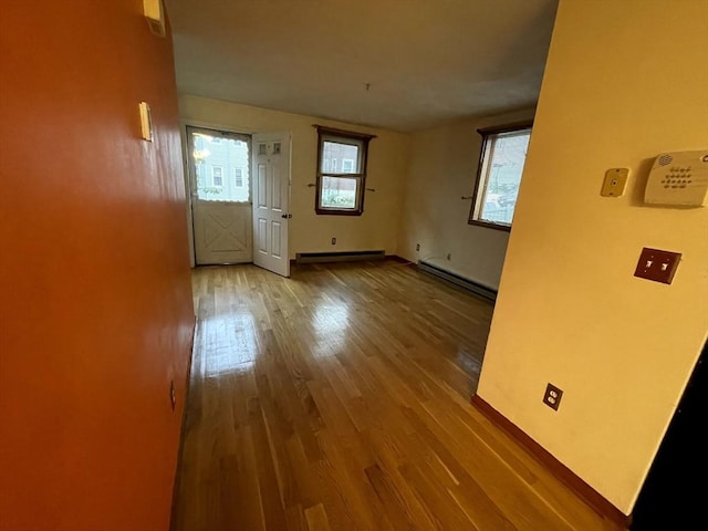 21 Hillside Ave Unit 21, Everett, MA 02149 - empty room with baseboard heating, a baseboard radiator, and wood finished floors