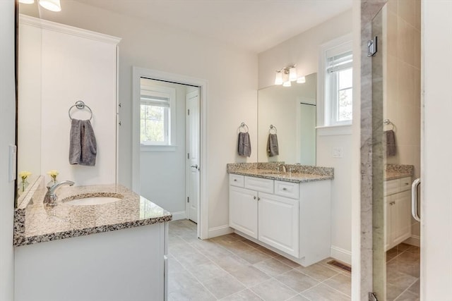 bathroom featuring baseboards, visible vents, two vanities, and a sink