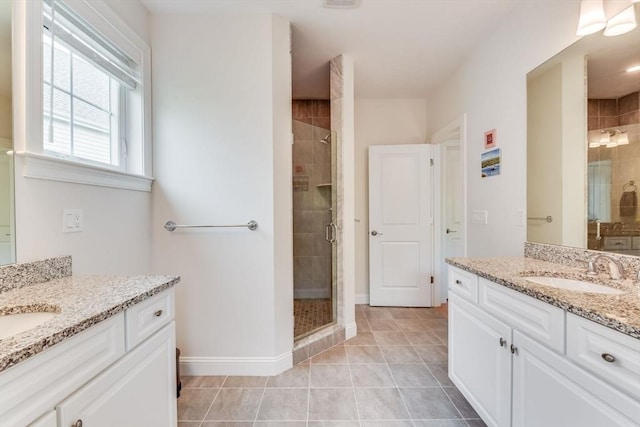 bathroom featuring tile patterned flooring, a shower stall, two vanities, and a sink