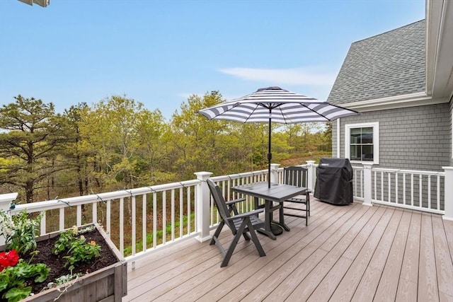 wooden deck featuring outdoor dining space and area for grilling